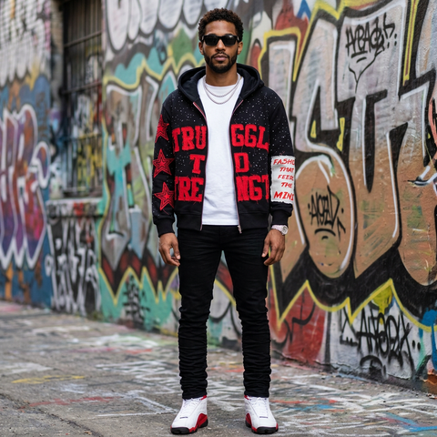Man wearing a black hoodie with red text in front of a graffiti-covered wall